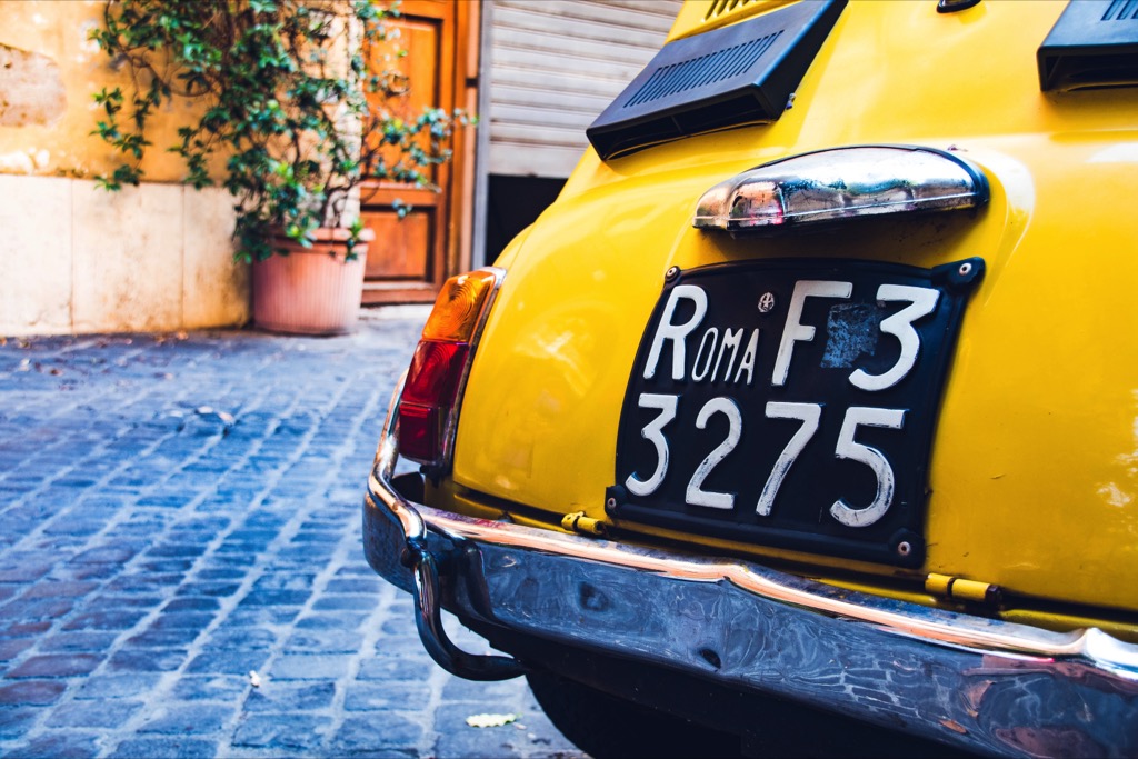 Gele Fiat auto geparkeerd in een straat in Rome.